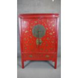 A 19th century Chinese red lacquered marriage cabinet with all over hand gilded decoration. H.175