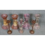 A collection of candlesticks. Including a pair of bronze effect candlesticks and various painted