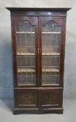 A C.1900 oak library bookcase with leaded glazed doors above panel doors with Art Nouveau inlay. H.