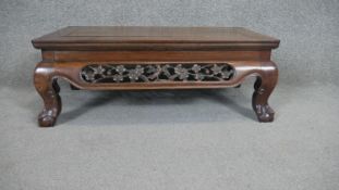 A Chinese hardwood low table with pierced and carved frieze on squat cabriole supports.