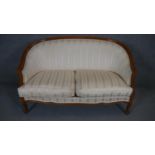 A Louis XV style two seater canape in striped upholstery on carved cabriole supports.