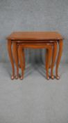 A nest of three French Provincial style fruitwood graduating occasional tables on carved cabriole