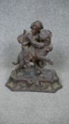 A late 19th century Black Forest carved limewood group, a young boy clinging to the back of a St