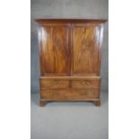 A 19th century linen press with dentil cornice above figured mahogany panel doors enclosing