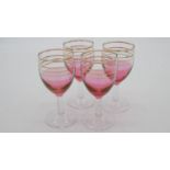 A set of four vintage painted pink wine glasses with gilded linear detailing and clear stems.