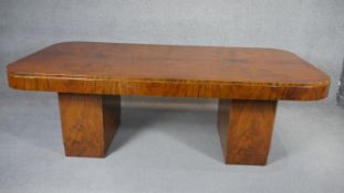 An Art Deco figured walnut dining table on twin block pedestals. H.75 W.215 D.107CM