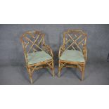 A pair of vintage bamboo conservatory armchairs with squab cushions on woven seats.