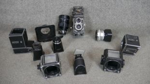 A Roliflex camera along with various Hassleblad camera parts including a Hassleblad 500EL/M camera