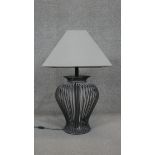 A vase design wrought iron table lamp with cream shade. H.79CM