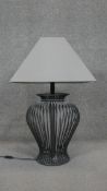 A vase design wrought iron table lamp with cream shade. H.79CM