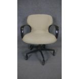 A vintage office chair with swivel and reclining action on a five spoke metal base on casters.