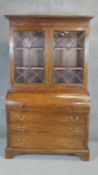 A 19th century mahogany and ebony strung cylinder bureau bookcase with fitted interior on bracket