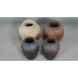 Four Asian carved wooden vessels, two with lotus flower and leaf design.