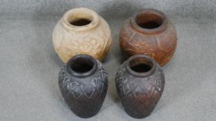 Four Asian carved wooden vessels, two with lotus flower and leaf design.