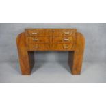 An Art deco figured walnut sideboard with three central drawers flanked by arched pedestals on a