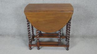 A vintage walnut drop flap dining table on barleytwist supports. h76 w76 d40/110