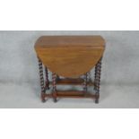 A vintage walnut drop flap dining table on barleytwist supports. h76 w76 d40/110