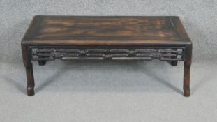 A Chinese Kang carved hardwood low table with carved pierced frieze on shaped supports. H.27 W.72