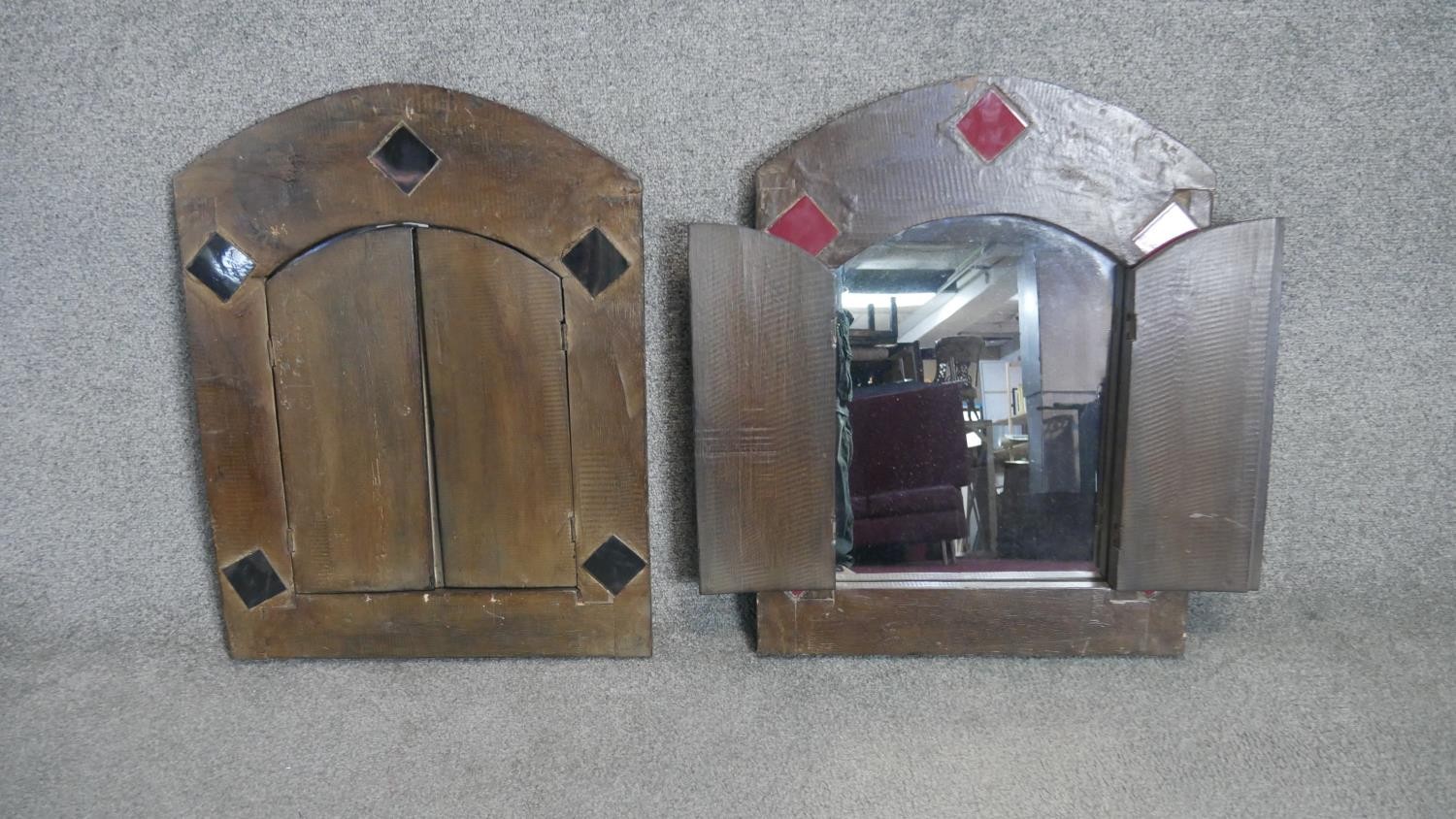 A pair of North African style wall mirrors in hardwood frames each fitted with a pair of panel