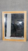 A contemporary bevelled wall mirror in inlaid hardwood frame. H.132 x W.107cm