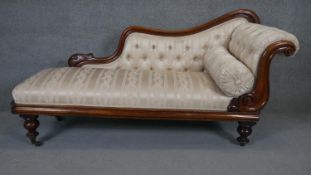 A Victorian carved mahogany frame chaise longue in deep buttoned floral upholstery on turned bulbous