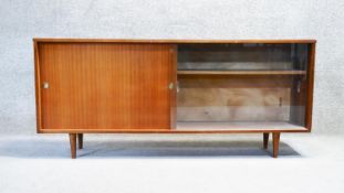 A mid century vintage teak sideboard with sliding glass and panel doors. H. 68 W.153 D. 28