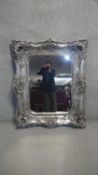 An ornate contemporary wall mirror in silvered Rococo frame. H.131 W.88