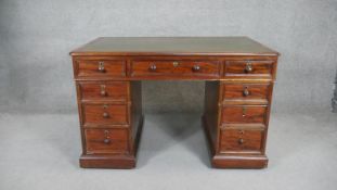 A mid 19th century mahogany three section pedestal desk with gilt tooled leather inset top on plinth