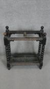 A mid century carved oak umbrella stand on bobbin turned supports with lift out metal drip tray. H