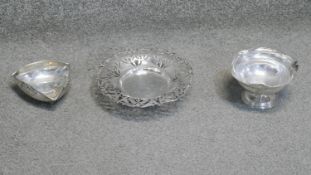 Three silver dishes. One tricorn shaped dish on three feet with relief scrolling decoration