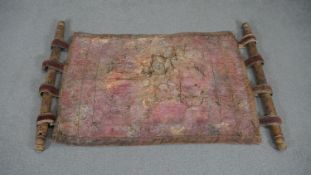 An embroidered leather wall hanging with painted stick design frame. L.124 W.75