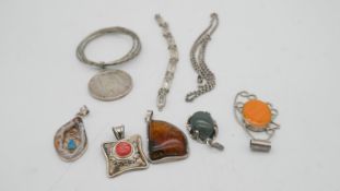 A collection of silver jewellery. Including an Egyptian silver coin in silver mount, a silver rolo