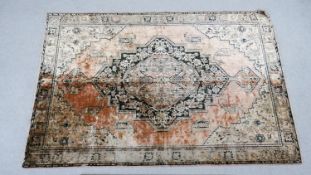 An antique silk machine made Eastern rug with central medallion on a rouge ground