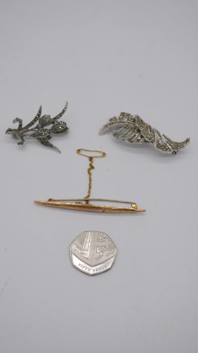 An engraved hollow marked 9ct gold bar brooch and two marcasite flower brooches. - Image 2 of 5