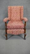 A mid century beech framed easy armchair in heraldic style upholstery.