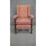 A mid century beech framed easy armchair in heraldic style upholstery.