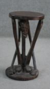 A carved African hardwood stool with crouched figural base. H.50 Diam. 28cm