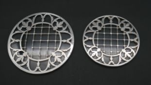 A pair of Mappin and Webb sterling silver and glass place mats with a pierced foliate design.