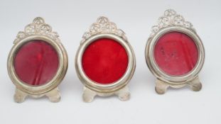 Three Egyptian silver pierced foliate design circular easel picture frames with red velvet backs.