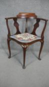 A C.1900 mahogany and inlaid corner armchair with floral tapestry upholstery raised on four