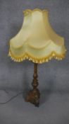 A gilt plaster foliate design table lamp with yellow silk shade with tassles. H.105