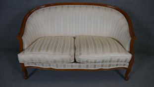 A Louis XV style two seater canape in striped upholstery on carved cabriole supports.