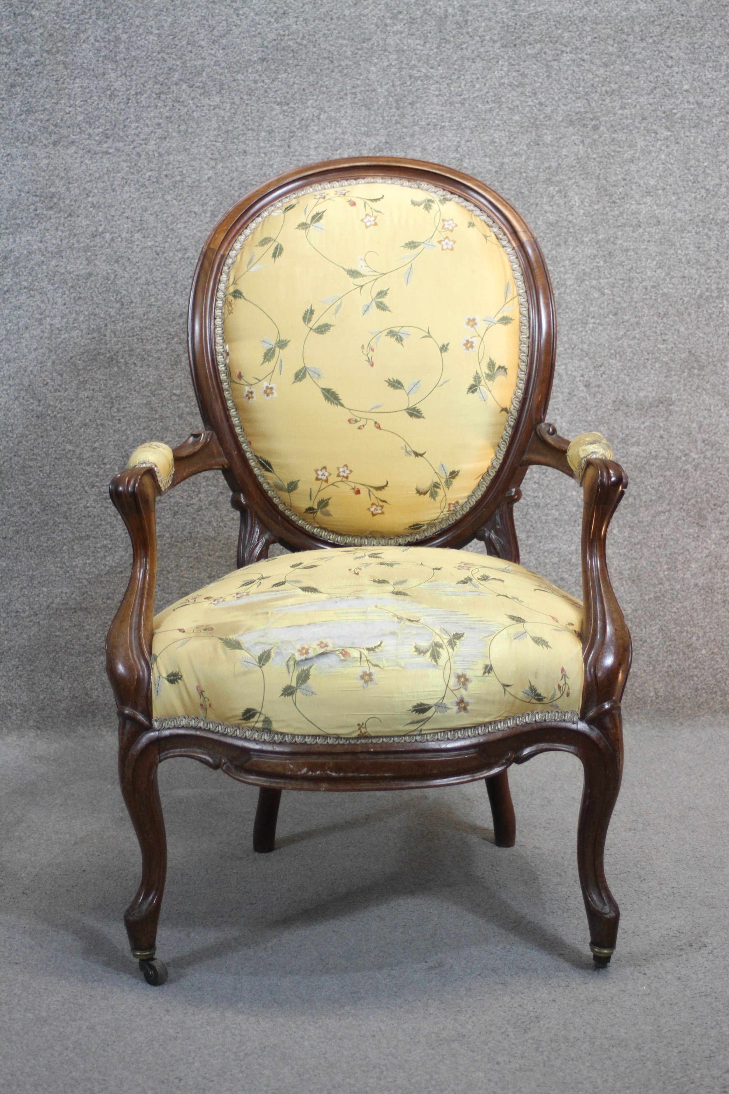 A 19th century mahogany framed French style armchair in floral silk upholstery raised on cabriole