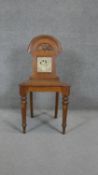 A late 19th century oak hall chair with inset Mintons tile to the back above panel seat on turned