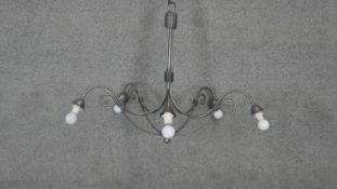 A wrought metal five branch chandelier with scrolling arms. Dia.90cm