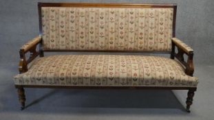 A late 19th century walnut framed canape in floral upholstery on turned tapering supports. H.105 W.