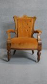 A Victorian burr walnut and inlaid armchair in deep buttoned velour upholstery on turned tapering