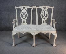 A Chippendale style painted twin chair back settee with drop in seat on carved cabriole ball and