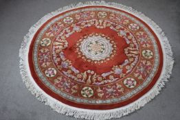 A red ground hand made woollen Chinese circular carpet. Diam. 190cm