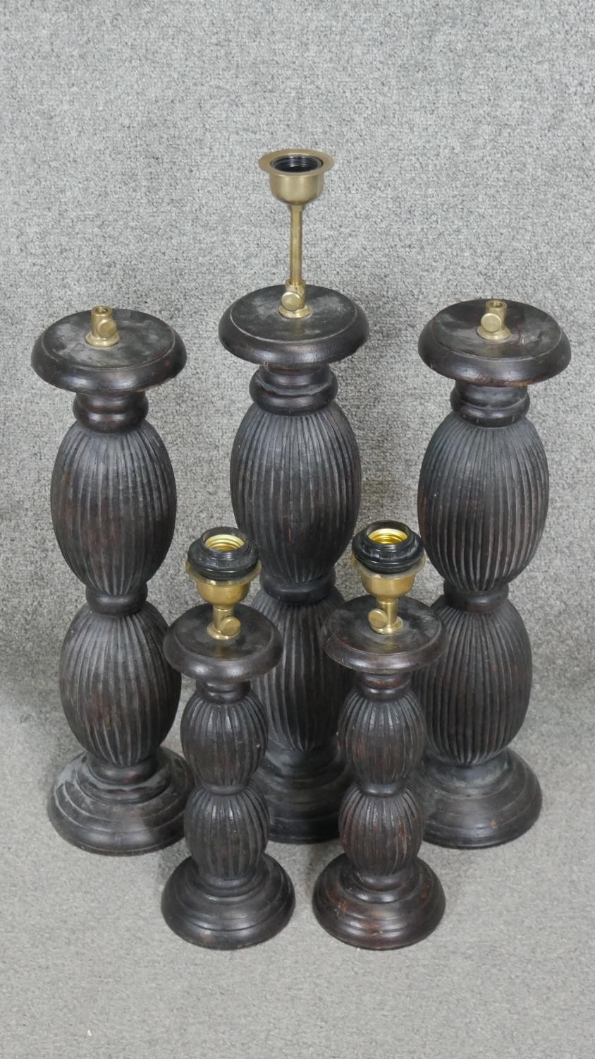 Four carved and stained table lamps with ridged bulbous design. H.53CM